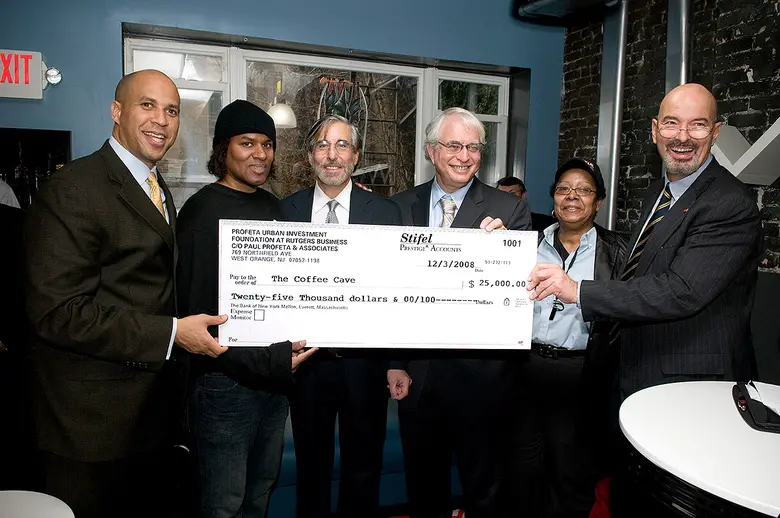 Center members, Cory Booker, and local owners of The Coffee Cave holding a check from Paul Profeta Urban Investment Foundation for $25,000