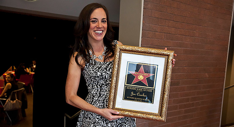 Jen Crocker holding a framed photo of here RBS Star in the Rutgers Walk of Fame