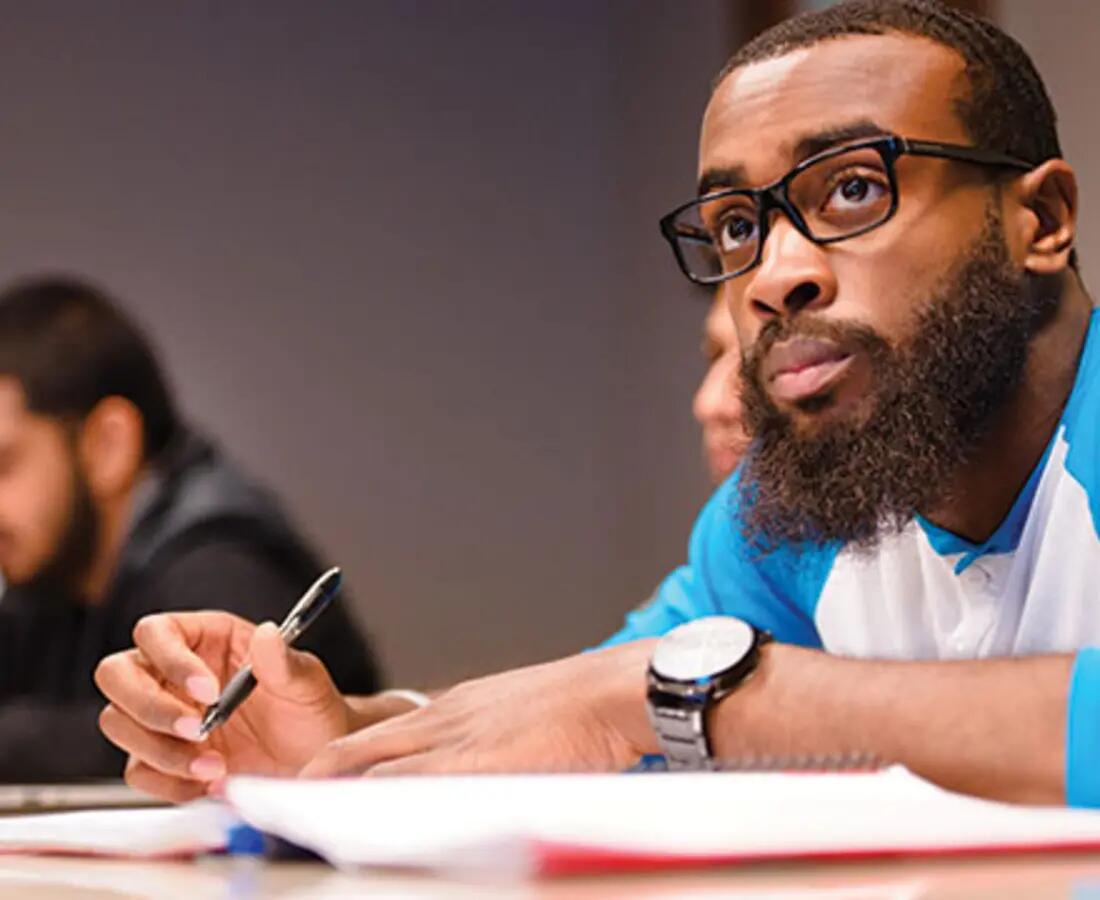 Undergraduate student taking notes in class.