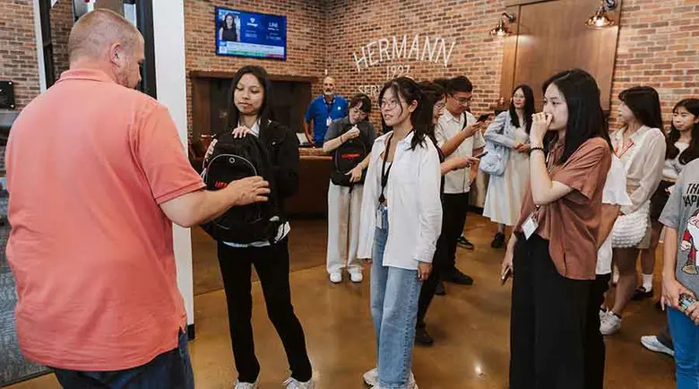 A Hermann Services employee handing out souvenirs to the students from Taiwan.