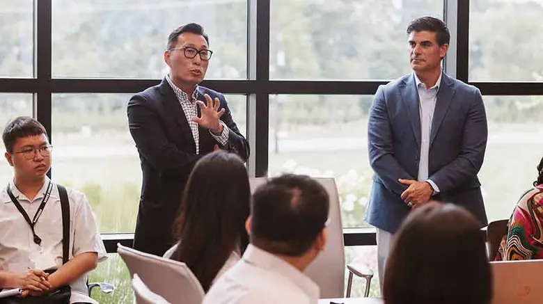 Photo shows Jeffrey Hermann, CEO of Hermann Services, listening to comments from Terry Chang of Fermosa Plastics.