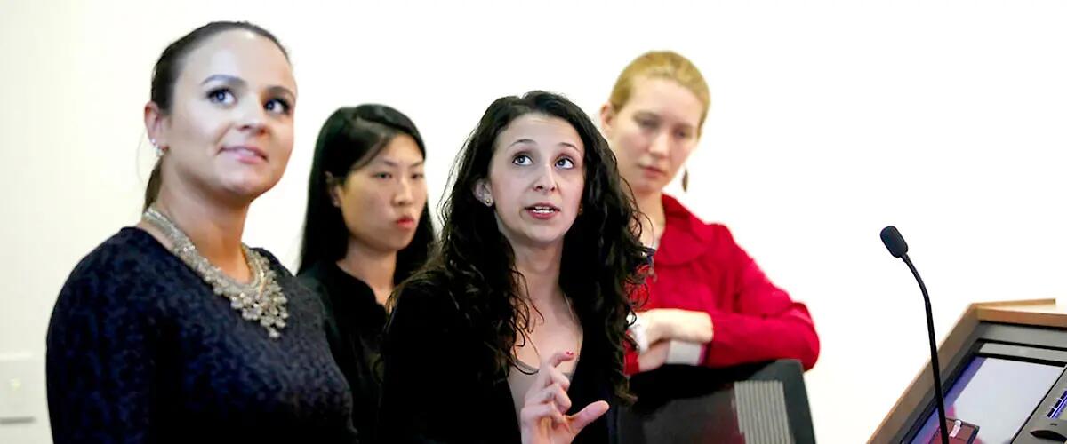 Four women giving a presentation using state-of-the-art technology