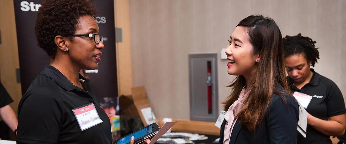 Student speaks with recruiter at career fair. 